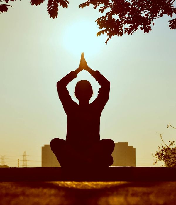 A person meditating peacefully outdoors in nature.